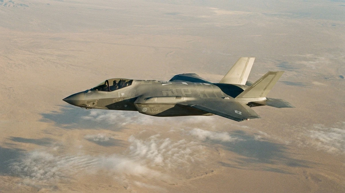 Illustration: F-35 fighter in flight over a desert landscape; CCA drones are designed to fly alongside crewed fighters